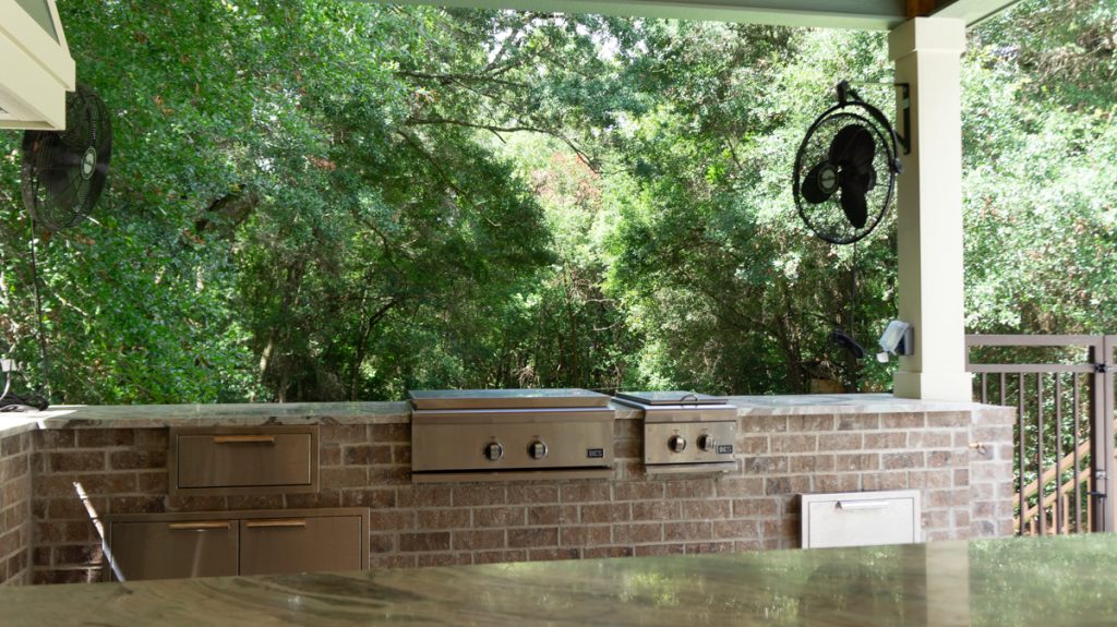 Built-in outdoor grill, burners, and storage beneath a covered patio